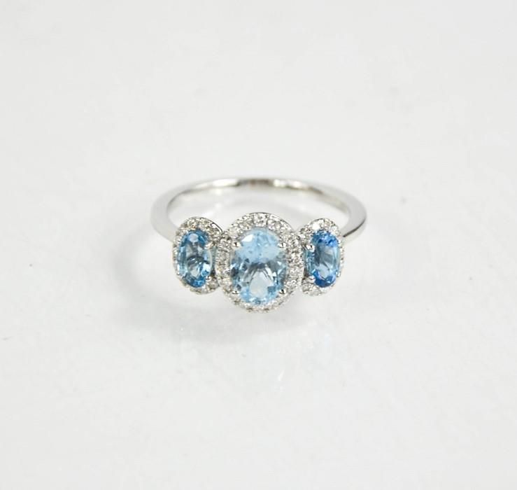 Null An 18ct gold aquamarine and diamond trilogy ring, J½, 2.65g.