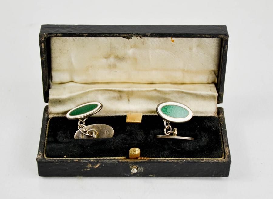 Null A pair of silver and green enamelled oval form cuff links, in presentation &hellip;