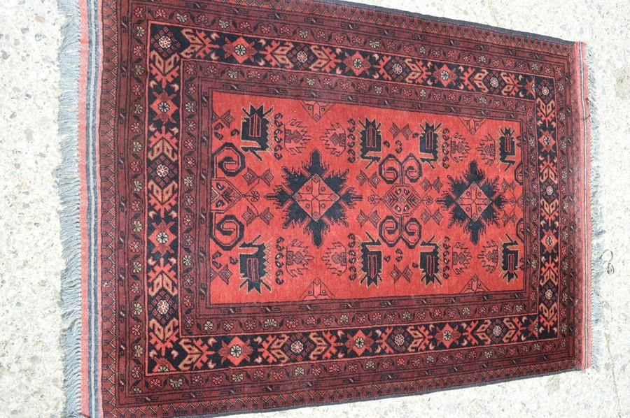 Null Un tapis rouge avec un motif aztèque, 105cm par 142cm