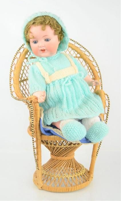 Null An Armand Marseille bisque doll No 996 and a wicker chair