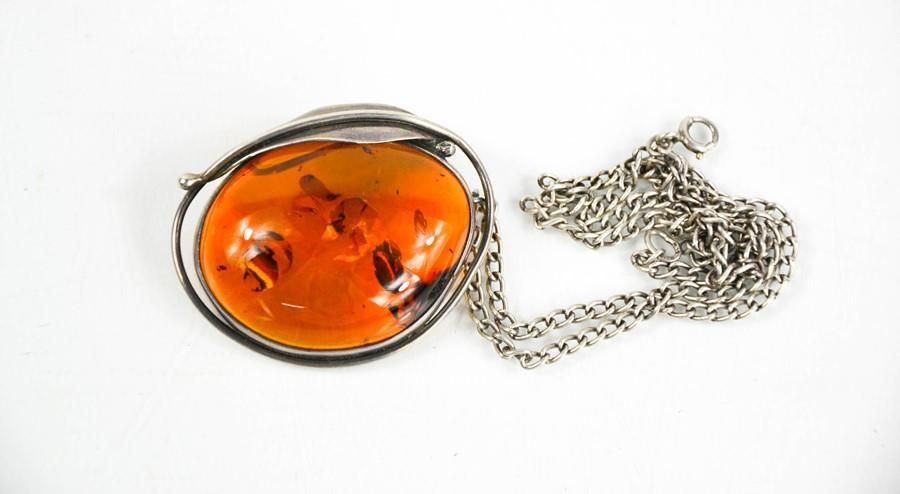 Null Un collier pendentif en argent et ambre, l'ambre mesure 4½cm de long.