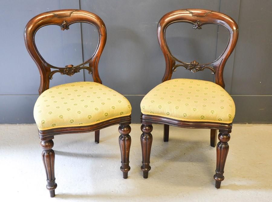 Null A pair of Victorian balloon back mahogany chairs, with upholstered seats.