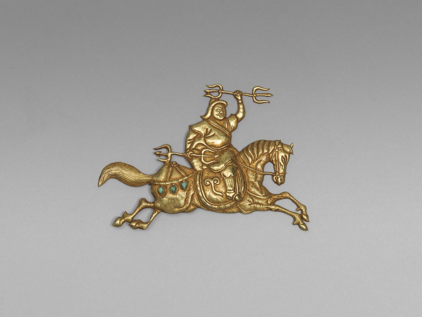Null 金盘750°/00，压印和镶嵌绿松石，描绘了一个蒙古骑手在其坐骑上驰骋的情景

20世纪

PB : 19,98 克

长：12厘米

(1137)