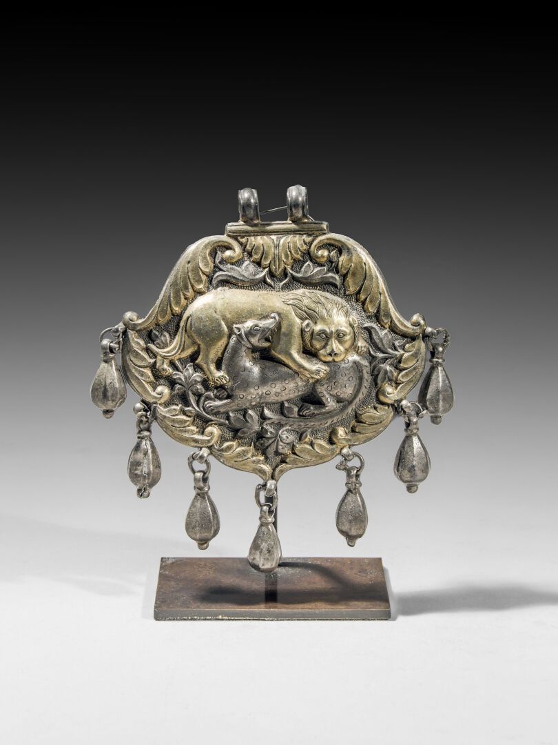 Null Gilded silver pendant showing a lion devouring its prey. 

Central Asia o&hellip;