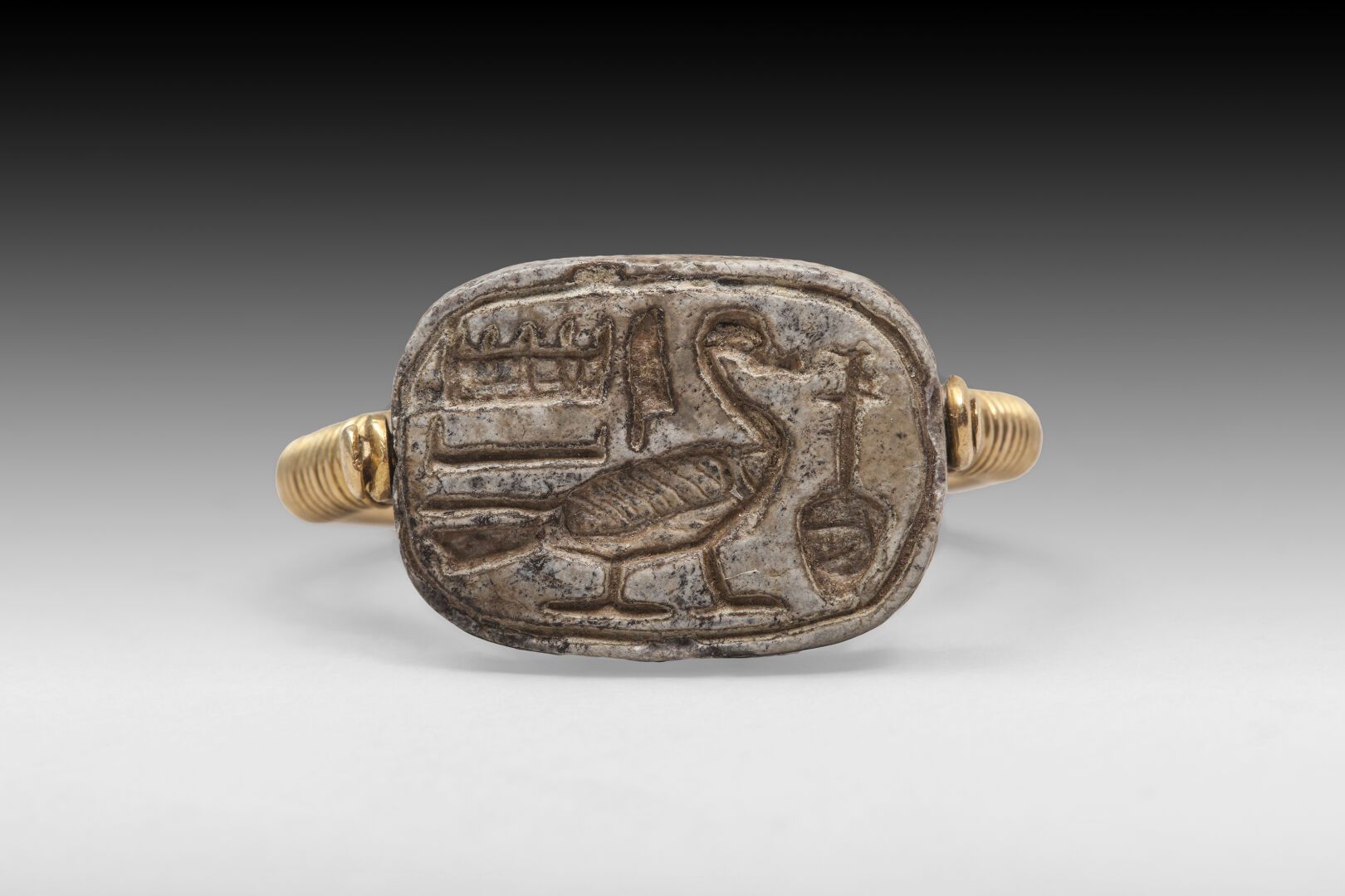 Null 750°/00的黄金戒指，上面有一个刻有象形文字的硬石板

埃及，古代时期。

手指大小：53

PB：3.56克

(1632)