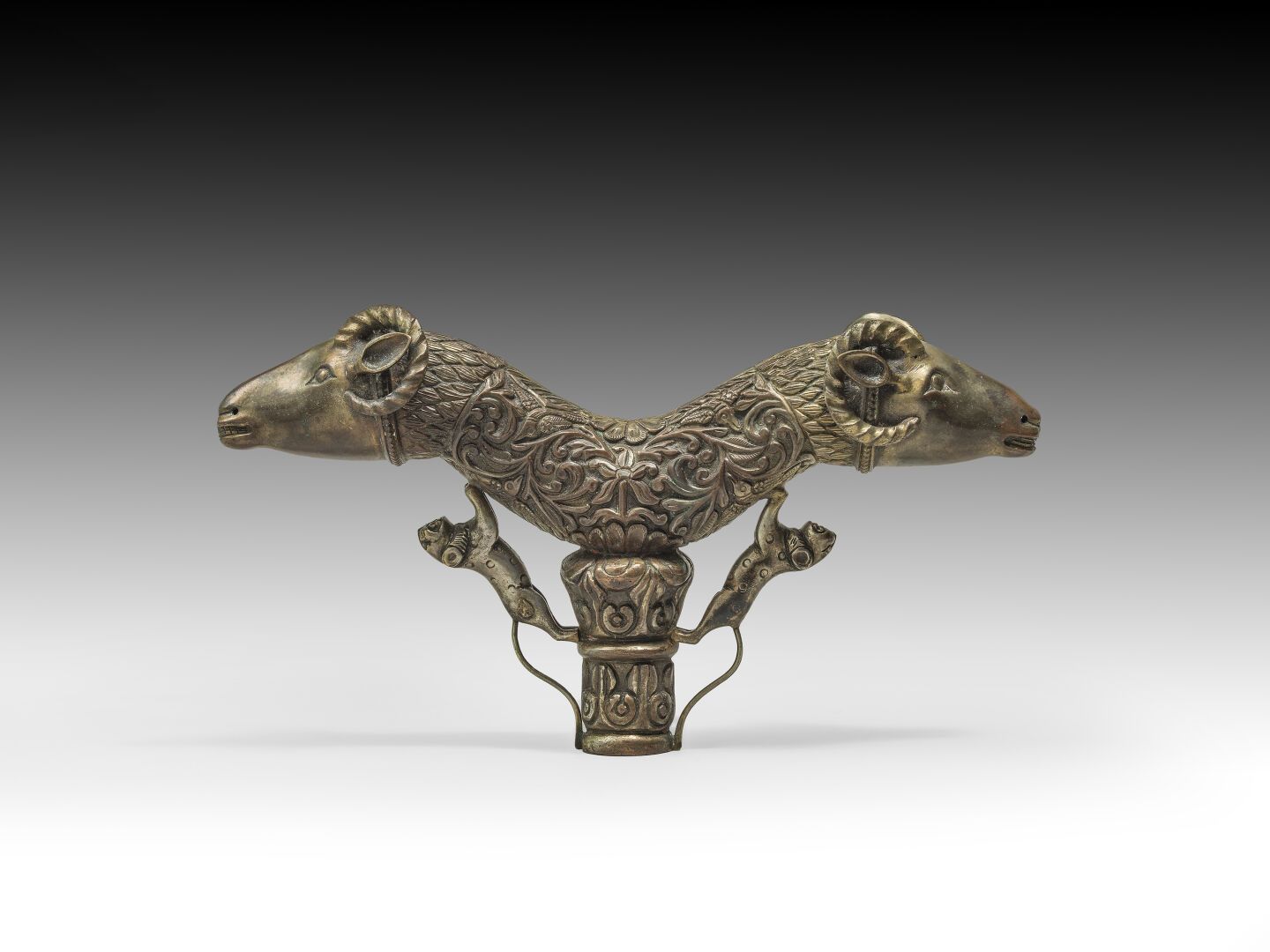 Null 一个镀金的铜合金浮雕HAMPE TOP，两端装饰着两只公羊。

印度，19世纪

H.约。15 cm - L : 25 cm

(0567和1319)