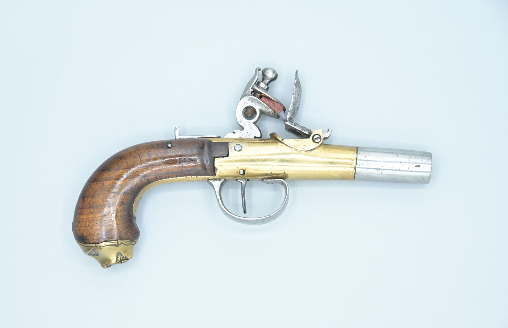 Null 燧发枪和苏格兰式手枪。青铜框架和强制子弹的枪管。带有海洋动物装饰的青铜鞍座。功能性机制。锤子的上颚是后来的。长度：17厘米。18世纪晚期
