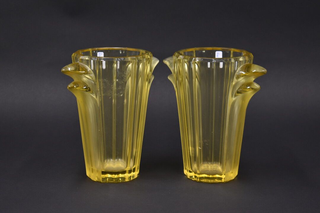 Null VERLYS。一对黄色玻璃花瓶，圆锥形瓶身，侧面有完整的把手，显示出叶子。签名。高度：19厘米。



专家：Cabinet MARCILHAC