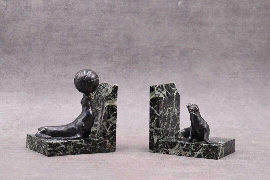 PAIRE DE SERRE-LIVRES A pair of green marble bookends decorated with sea lions i&hellip;