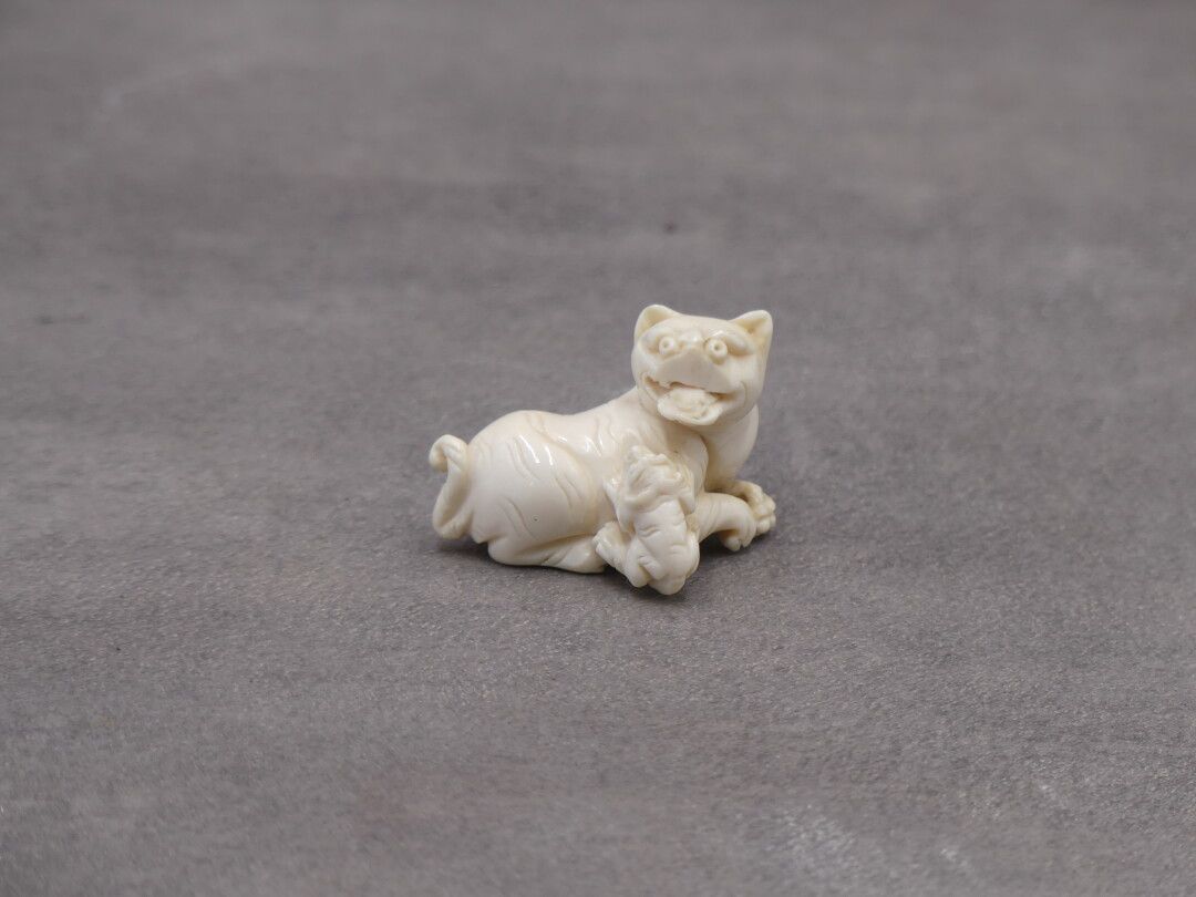 Null Netsuke en ivoire figurant un chien de Fo. Dimensions : 3 x 4 cm