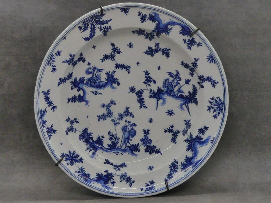 MOUSTIER MOUSTIER.蓝色camaïeu装饰的陶器盘子à la Bérain。18世纪。直径：40厘米。