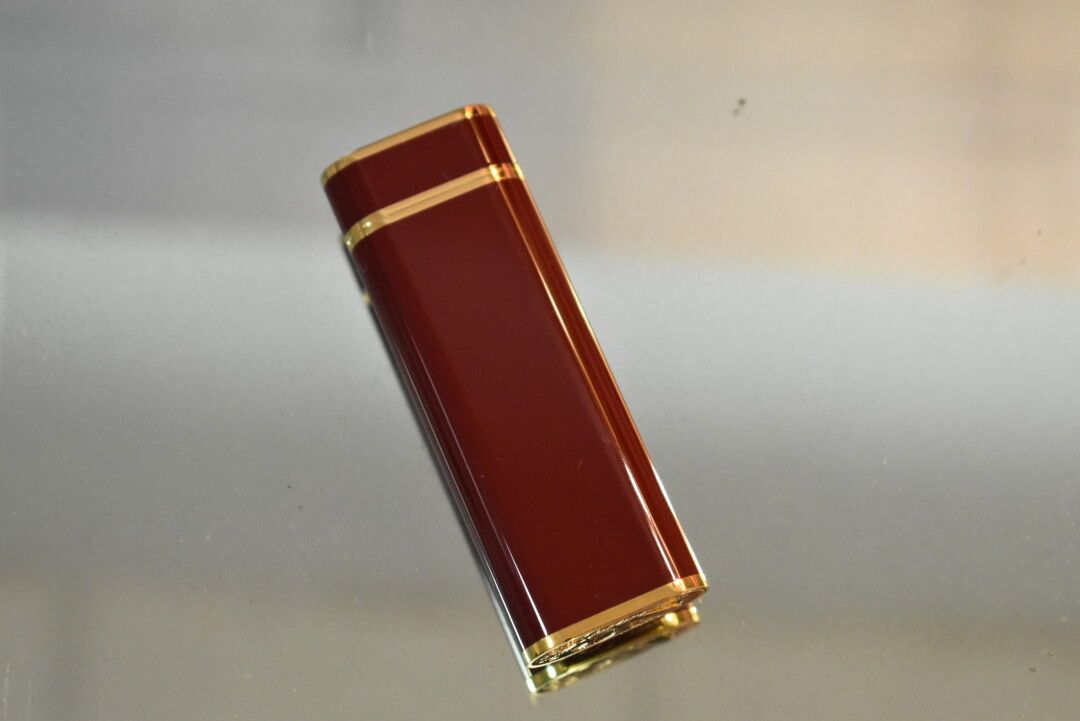 Null CARTIER. Must collection. Lighter in gold metal and red lacquer, numbered a&hellip;