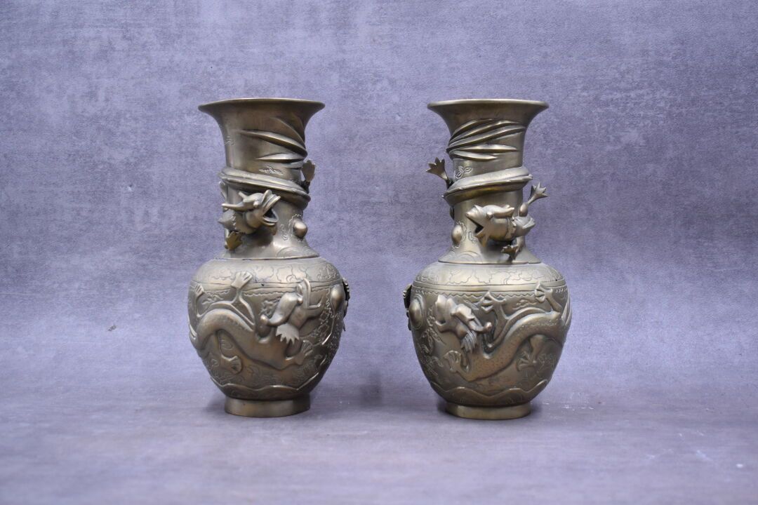 CHINE. 一对铜质花瓶，有镀金的光泽，上面有浮雕的龙纹。在基地下签名。高度：25厘米。

颈部直径：10厘米