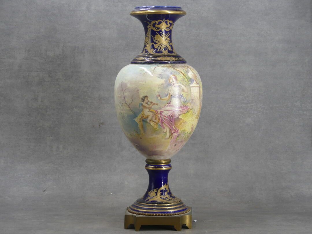 Null 在SEVRES的味道中。一个陶制的柱形花瓶，在蓝色背景上装饰着一个带着普提和镀金的女人。底座为鎏金青铜，有珍珠楣。高度：45厘米