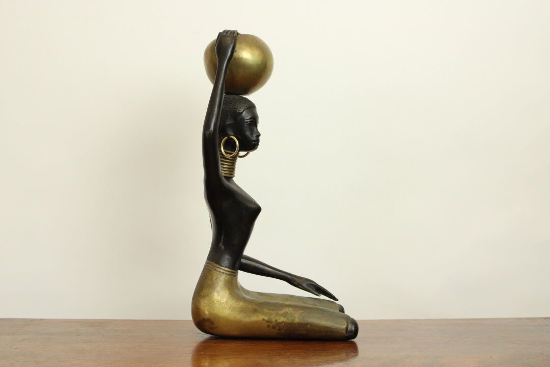 Null 20世纪学校，青铜主题，有棕色的铜锈，代表一个女人和一个非洲风格的水壶。尺寸：35.5 x 18厘米。
