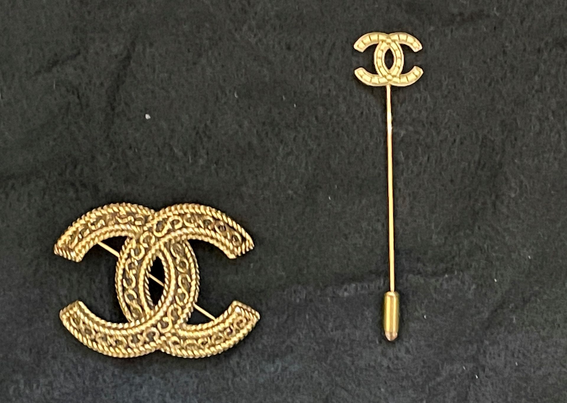 Null 香奈儿。黑底鎏金金属的双C胸针。

有签名和编号的。

3,5 cm x 4,5 cm

有盒子。

鎏金金属的小领带针，上面有双C的字样。签名。