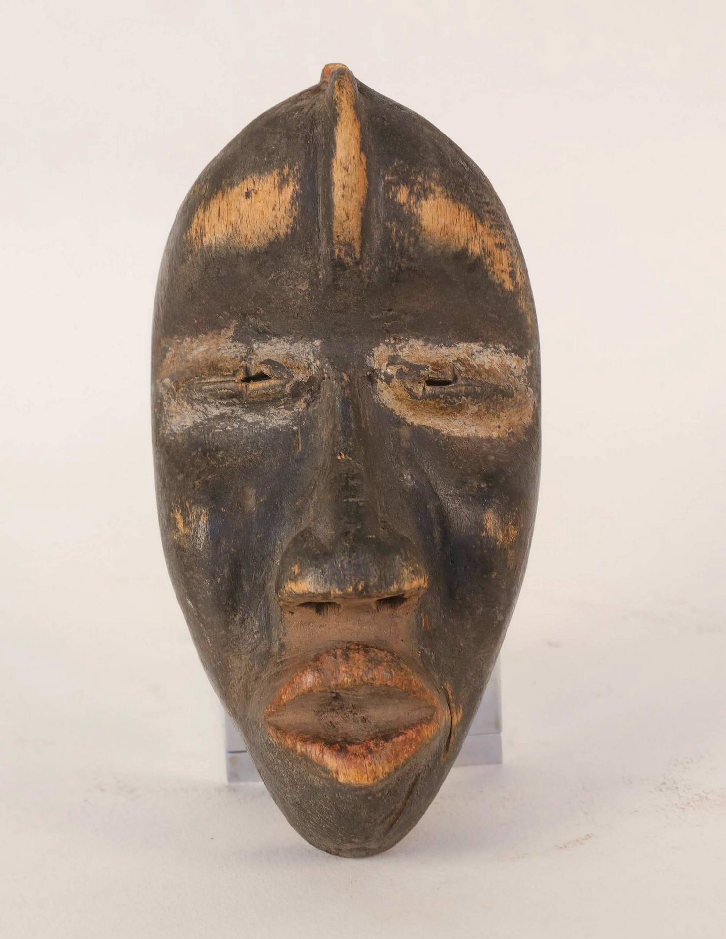 Null DAN，象牙海岸。木制面具有黑色的铜锈，面部呈椭圆形，有突出的颧骨和正面的中肋。失踪。(参考10) 高度：21厘米。