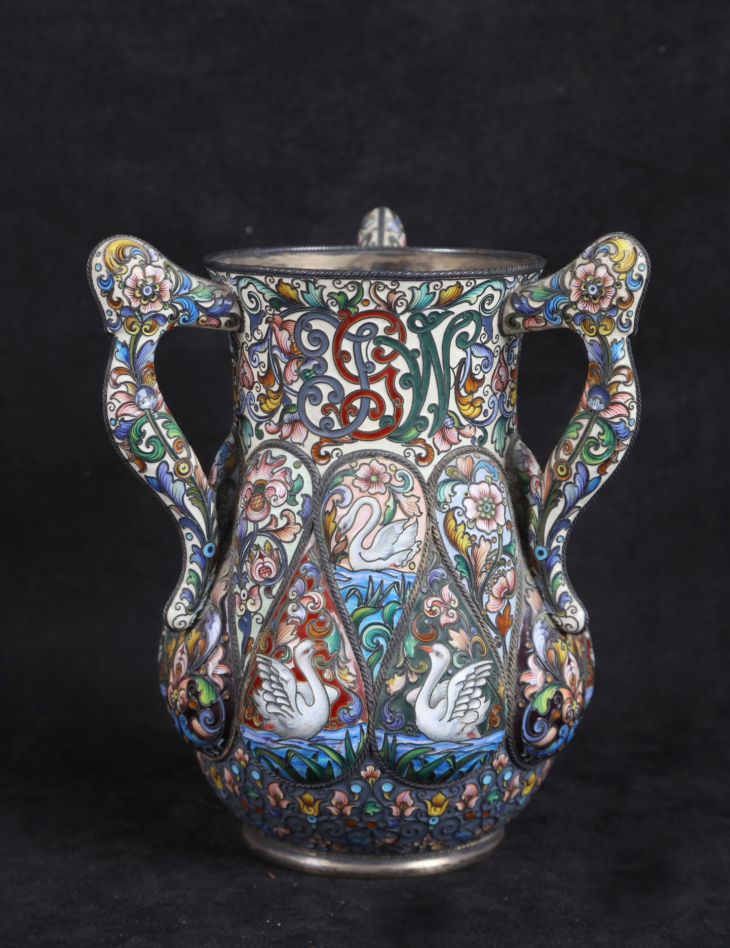 Null 俄罗斯
大型三柄花瓶，镀金88 Zolotniks（千分之九百一十六），呈柱状，置于圆形底座上，有粉色色调的多色掐丝珐琅装饰，瓶身有代表珐琅白天鹅游动&hellip;