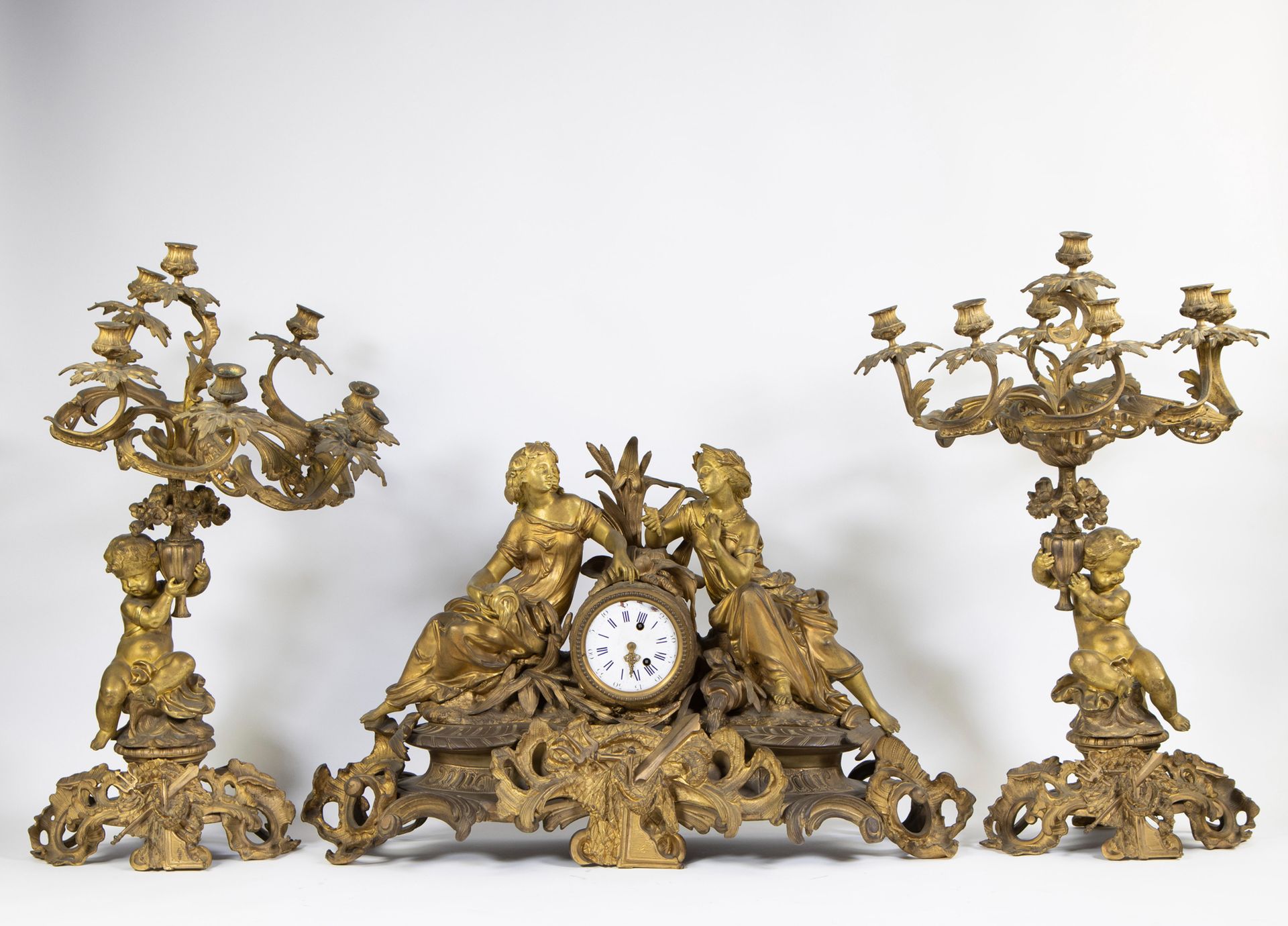 Null 一个令人印象深刻的由三部分组成的路易十五镀金时钟，来自法国著名的钟表制造商Guiche Palais Royal。壁炉钟上装饰着两个坐着的女孩。烛台是&hellip;