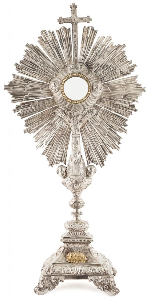 Null 镀银和镀金的金属十字架，有凿刻的装饰和圆形的阳物，周围有阵阵的直射光，上面有一个拉丁十字架。S. XX

高度：61 cm