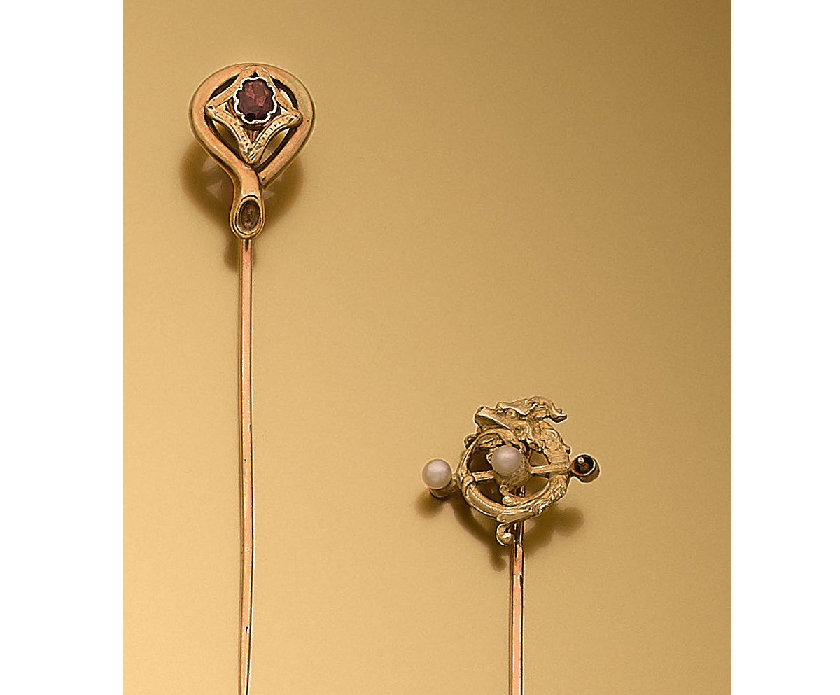 Null 两件18K(750‰)黄金领带夹，镶嵌有石榴石的回字形图案或镶嵌有两颗养殖珍珠的龙形成的环形图案（事故，缺失）。
毛重：5.04 g
