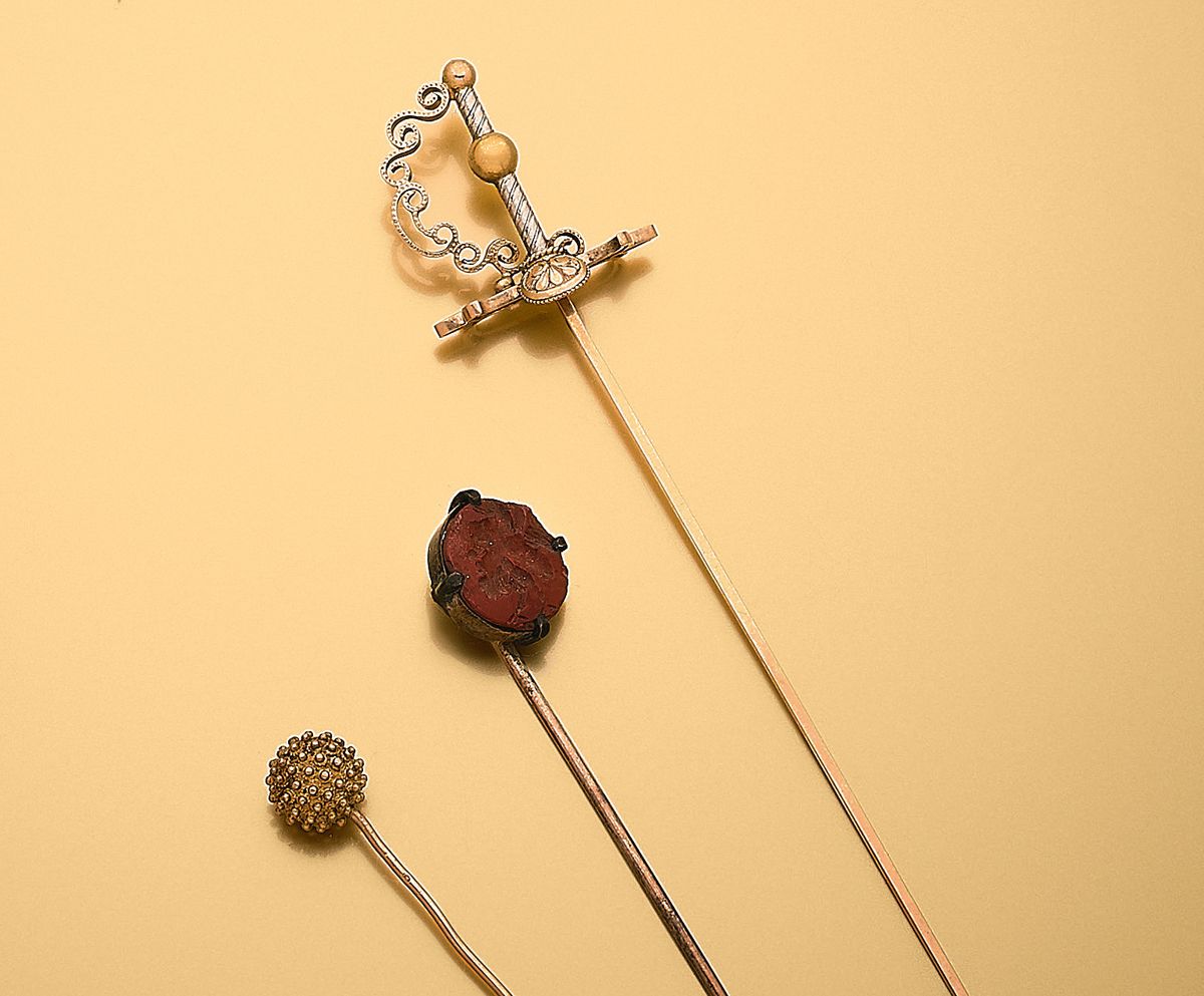Null 一套三个18K（750‰）黄金、9K（375‰）黄金合金和金属领带针，描绘了一把剑，装饰着碧玉球体或凹雕（意外）。
毛重：6.54 g