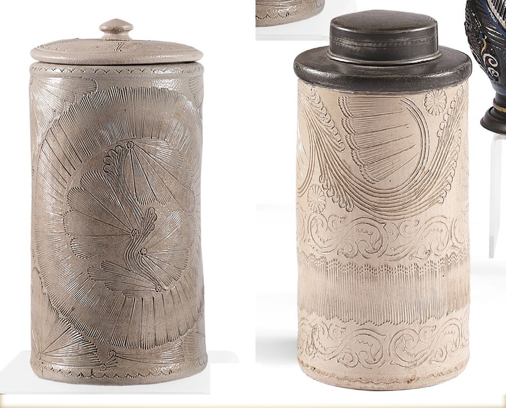 Null 两个圆柱形的炻器壶，有阿拉伯式和叶子的图案，还有它们的盖子。
西格堡，18世纪。
高: 19.5和21.5厘米
状况: 盖上有一缺口。