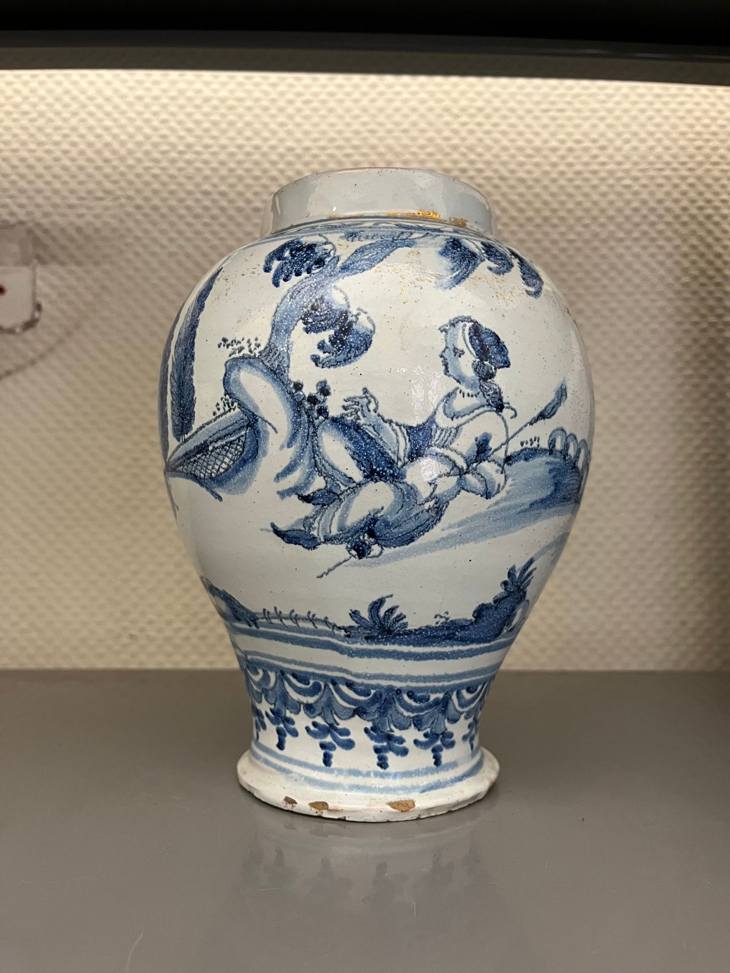 NEVERS 卵形陶器花瓶，蓝白相间的风景背景上有一对夫妇和一只狗的装饰。
18世纪初（碎片）。
高度：22,5厘米