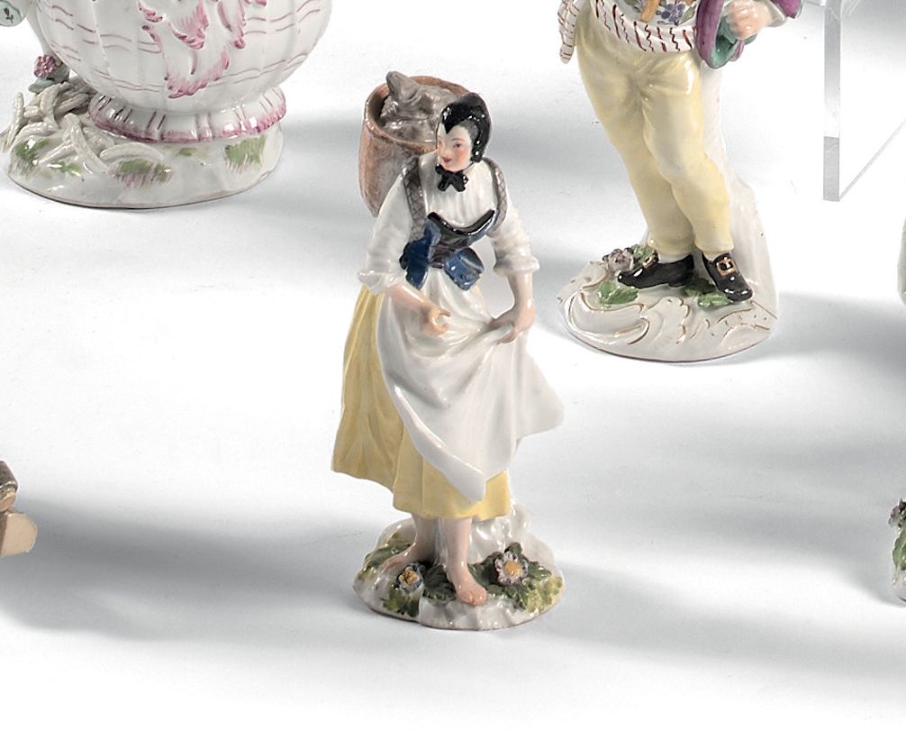 MEISSEN 代表商人的雕像，手拿围裙，背上有一个篮子，站在一个鲜花的底座上，有多色的装饰。
底座上有标记。
18世纪（在两端有非常小的修复）。
高度：11.&hellip;