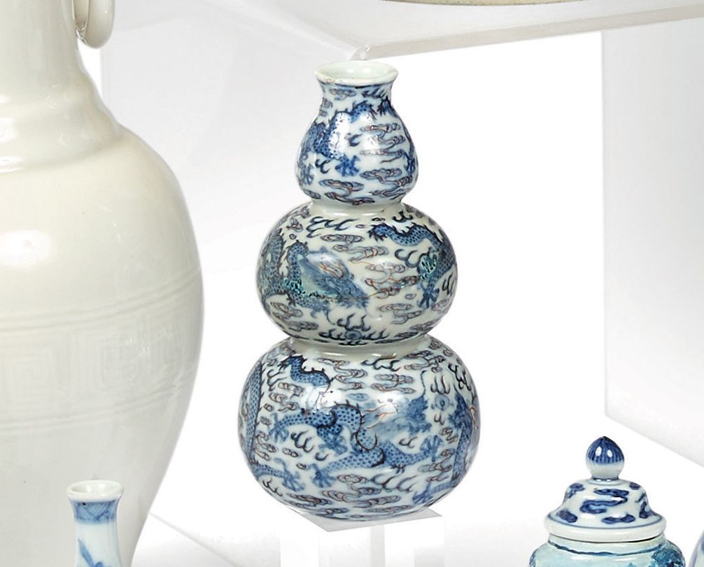 CHINE 一个蓝色的三弓形花瓶，上面有赭石色的龙和造型云的亮点装饰。
18世纪，乾隆时期。
高度：15厘米