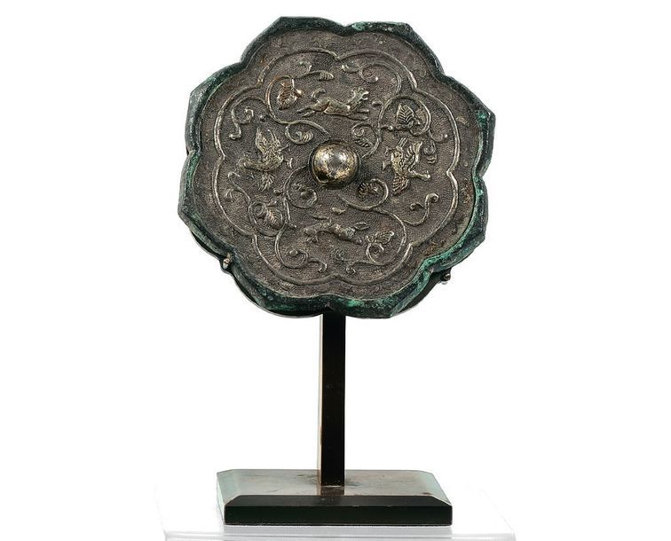 CHINE - Dynastie des Tang (618-907) 
Miroir polylobé en bronze incrusté d'une fe&hellip;