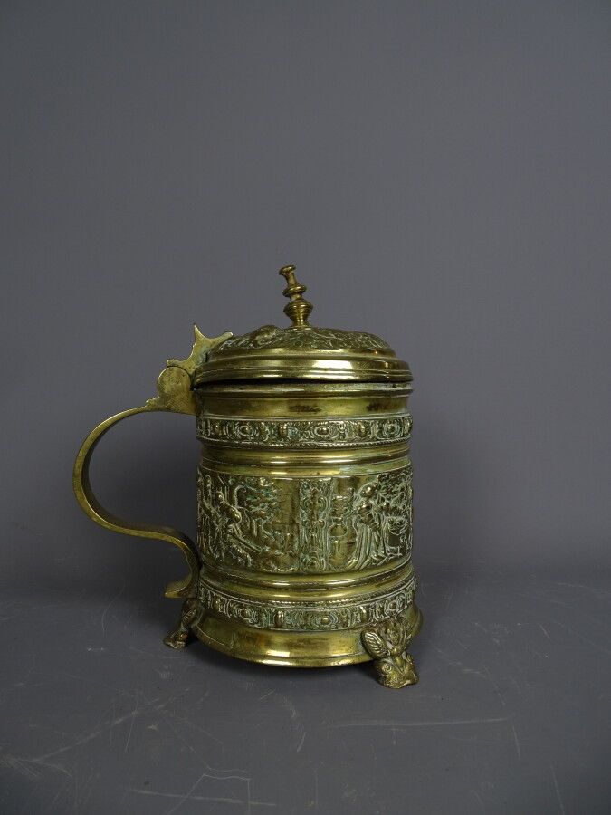 Null A bronze mug in the Renaissance style, decorated with characters, tripod. S&hellip;