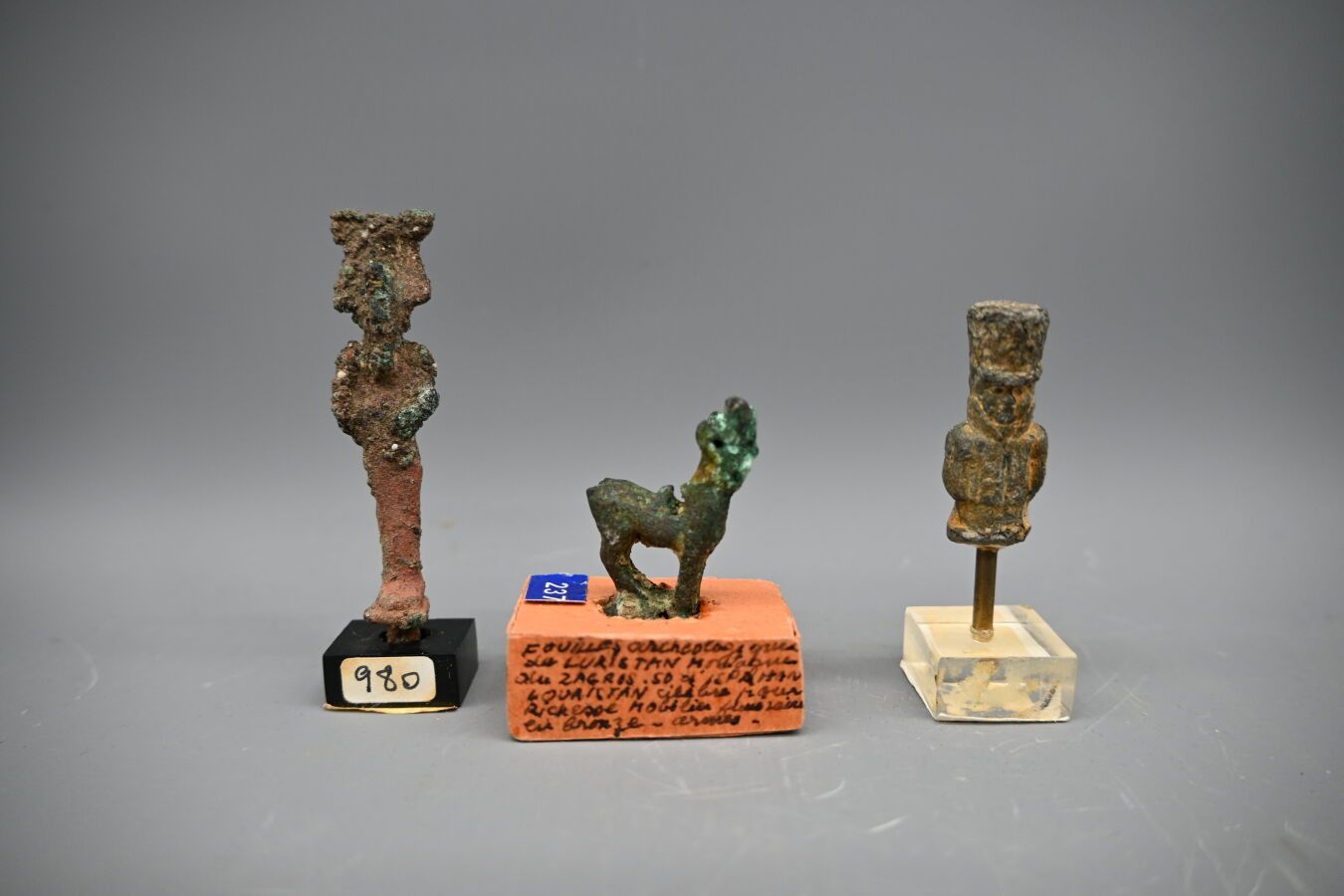 Null Lotto di tre amuleti: Uno stambecco in bronzo (3 cm) del Luristan; un Osiri&hellip;