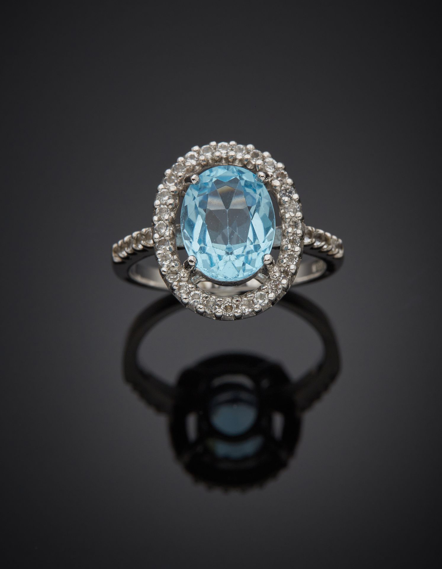Null 银质（925‰）镂空戒指，镶嵌着一颗椭圆形的蓝色托帕石，周围和肩部有无色的托帕石。 
指头：55。毛重：4.3克。