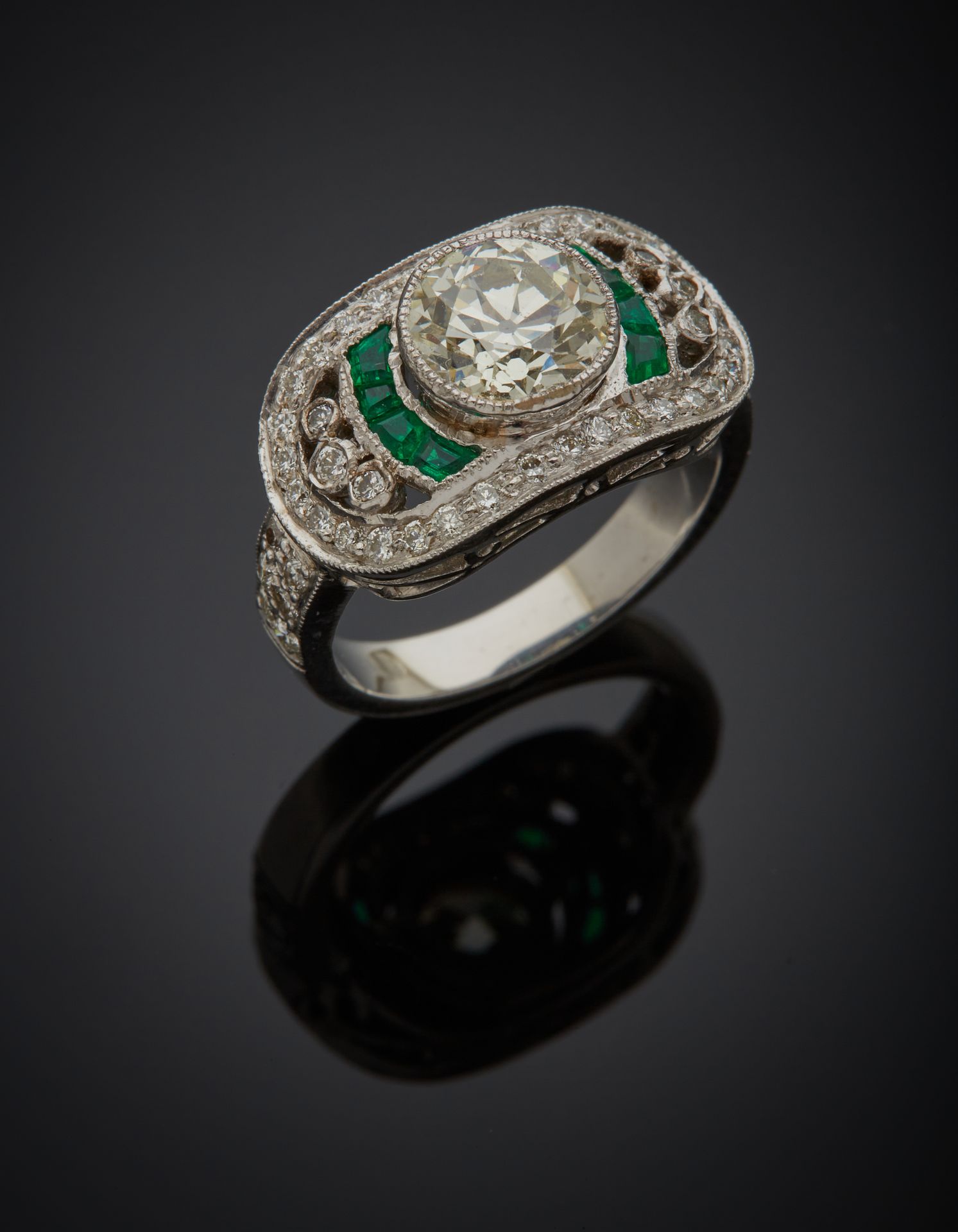 Null 大型镂空白金（750‰）戒指，镶嵌一颗老式切割钻石，重约1.7克拉，周围有明亮式切割钻石，肩部有校准的祖母绿。
指头：54。总重量：8.5克。
