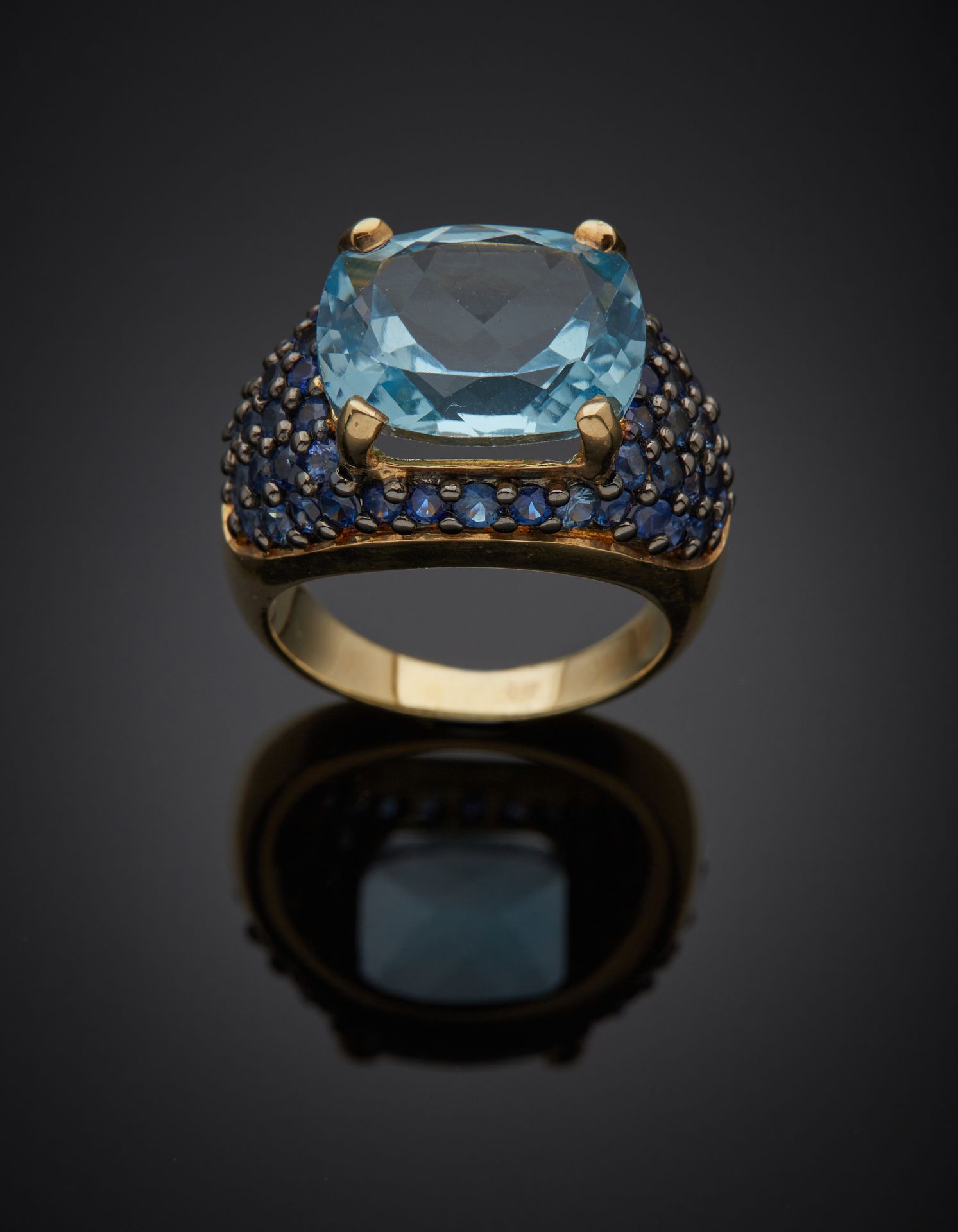 Null 发黑的银和镀金 "圆顶 "戒指（最小尺寸为800‰），镶嵌着一个大的枕形蓝色托帕石，周围是铺满的蓝宝石。 
指头：54。毛重：9.3克。