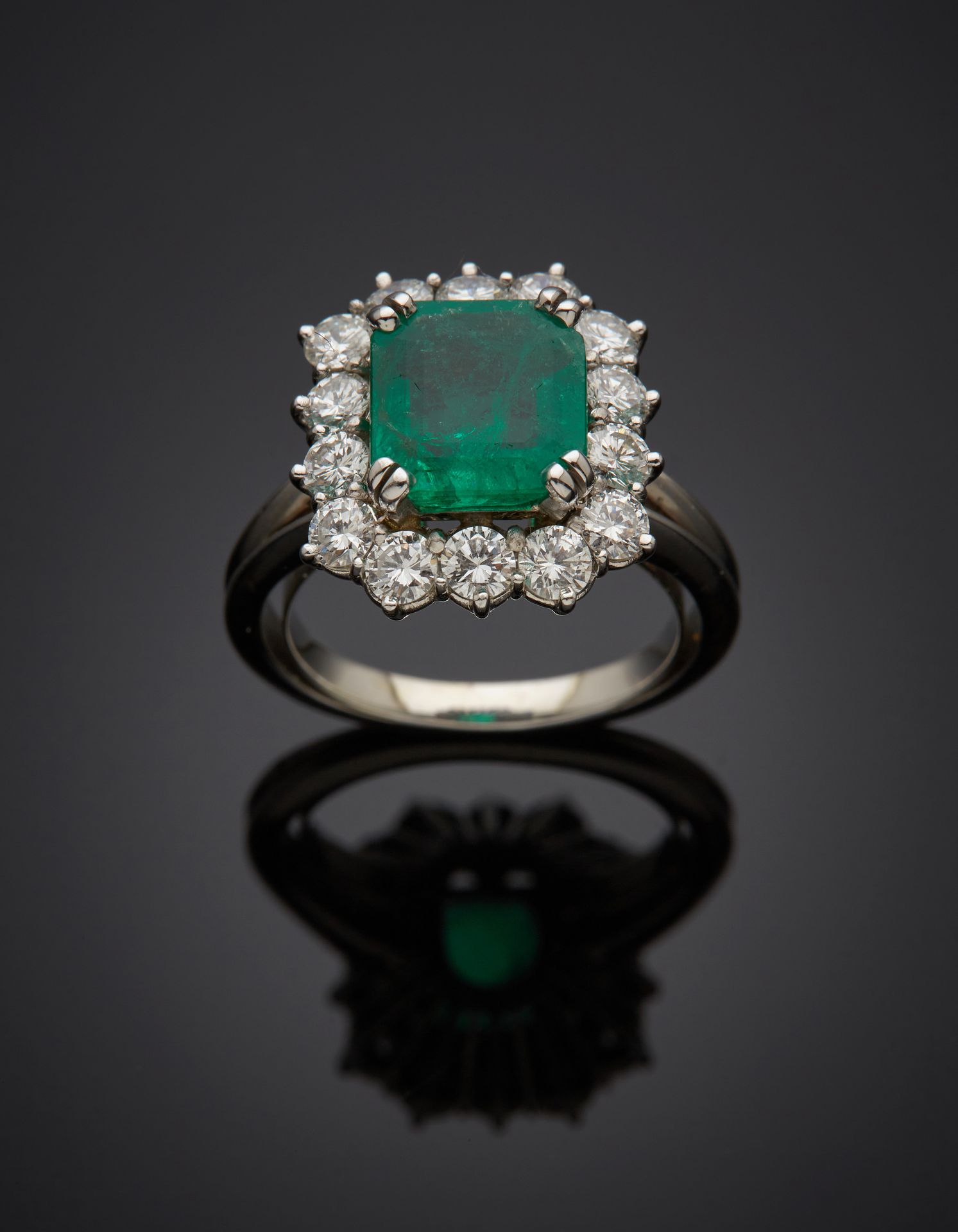 Null 铂金(950‰)和白金(750‰)镂空 "雏菊 "戒指，镶嵌着一颗长方形、阶梯式切割的哥伦比亚祖母绿，周围是明亮式切割钻石。 
绿宝石附有一份日期为2&hellip;