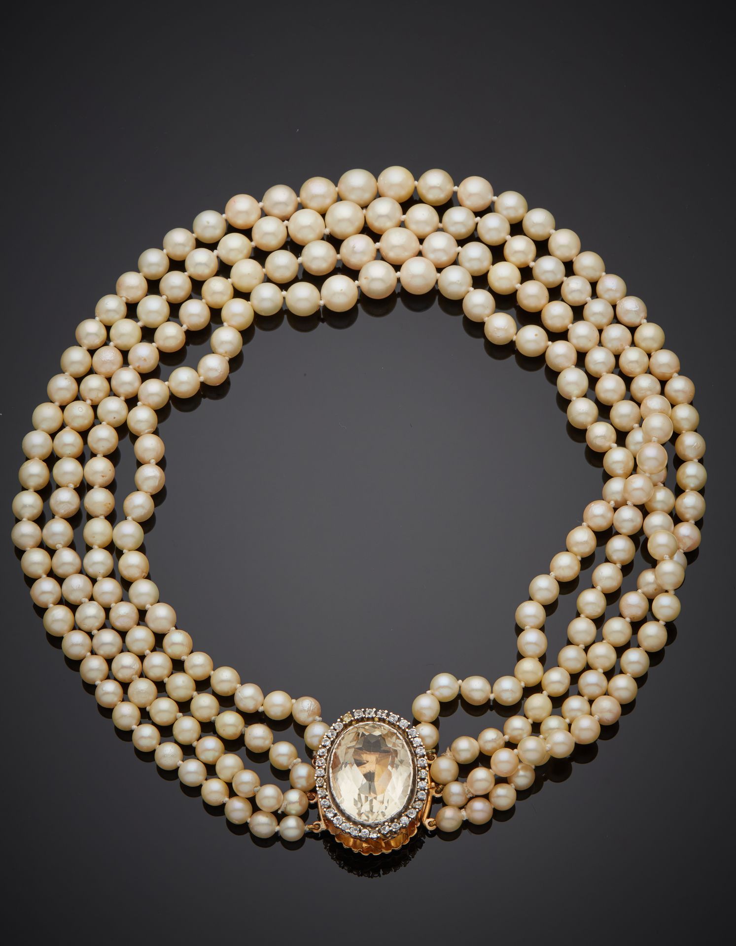 Null 项链由四排乳白色养殖珍珠组成，呈滴状。黄金和白金（750‰）扣子上镶嵌有白色宝石，包括一个较大的椭圆形宝石。 
珍珠的直径：5.5至9毫米。
长度：3&hellip;