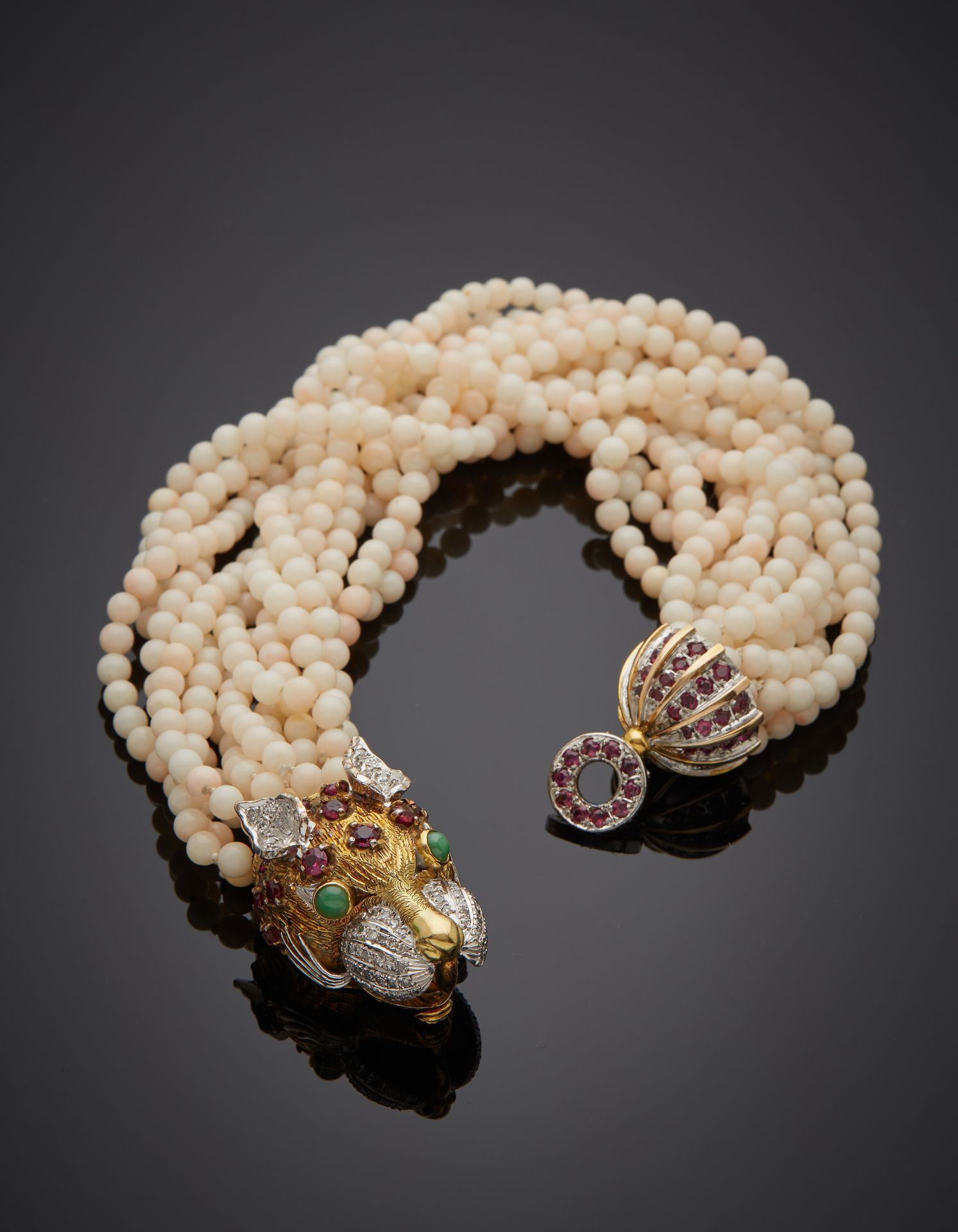 Null 豹子 "手镯由12排扭曲的珍珠组成，模仿白珊瑚。雕刻的黄金和白金(375‰)9克拉chased扣子上镶嵌着钻石和红绿宝石。大约在1980年。
长度：2&hellip;