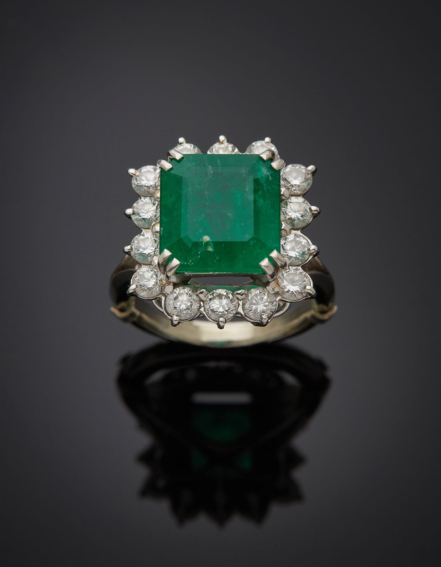 Null 方形铂金(950‰)和白金(750‰) "雏菊 "戒指，镶嵌着一颗阶梯式切割祖母绿，重约5.5克拉(内含物)，周围有14颗明亮式切割钻石。 
手指：5&hellip;