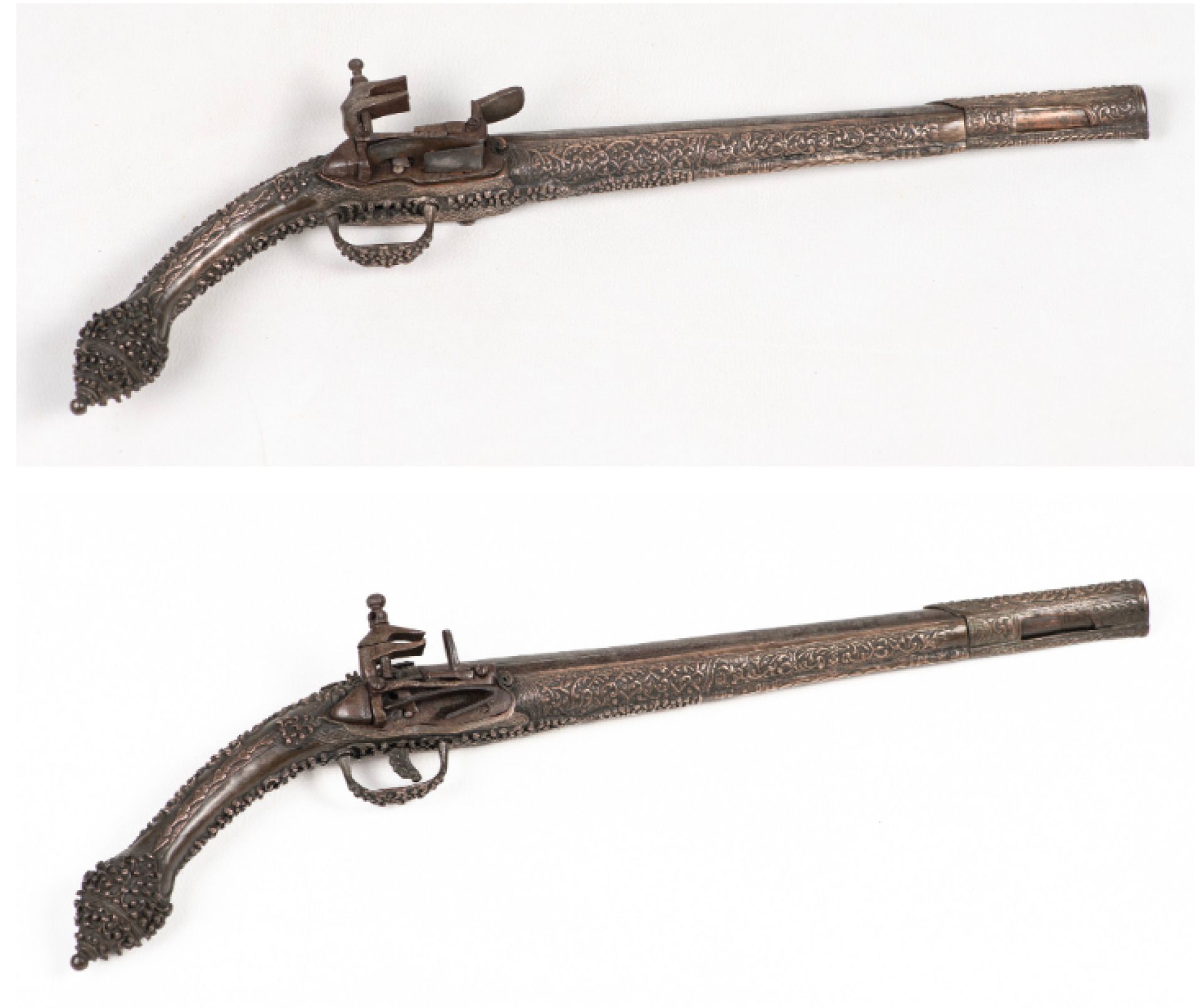 Null 一对 19 世纪的东方（巴尔干）手枪，铜质装饰，枪身覆盖精美的银色铜框，其中一把手枪的扳机缺失，枪托下部缺铜、
