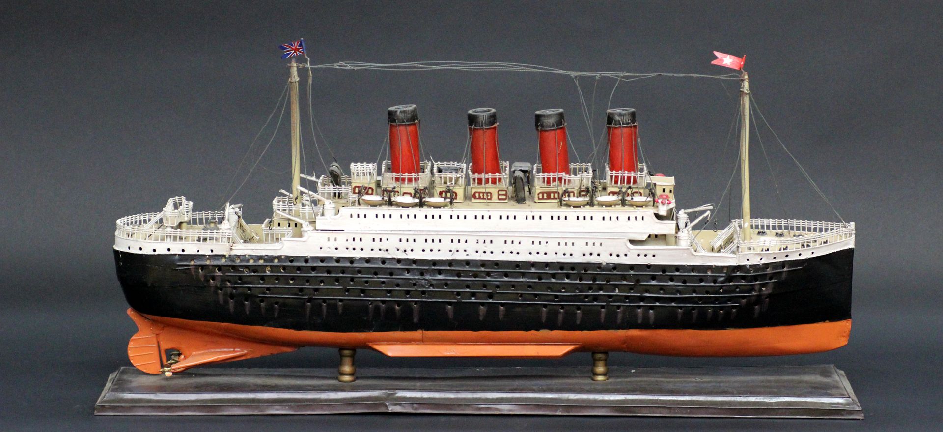 Null 一艘悬挂英国白星航运公司旗帜的跨大西洋班轮模型（可能是泰坦尼克号）。由金属板制成。黑色船体，四个烟囱，三个螺旋桨，白色上层甲板和红色烟囱。大约1880&hellip;