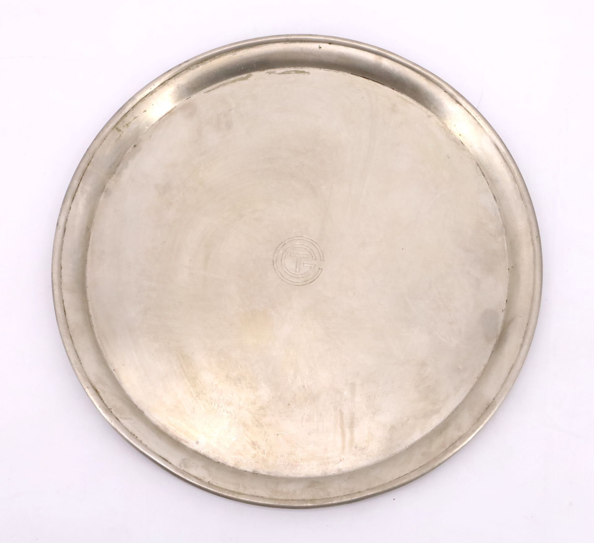 Null CGT诺曼底号圆形银盘，中间是诺曼底号邮轮使用的字样。Christofle之家的作品。直径40厘米。因使用而产生的划痕