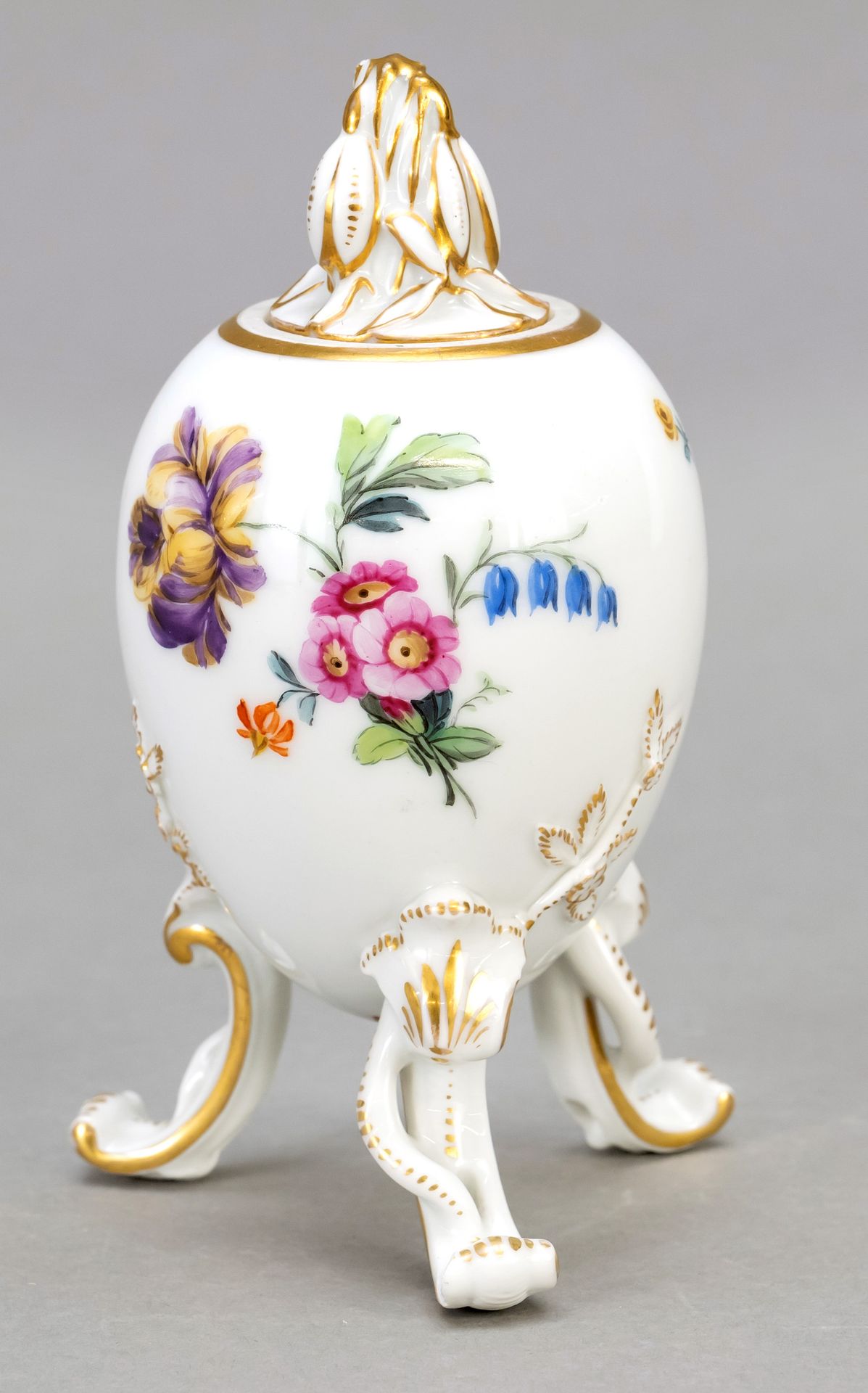 Null 复活节彩蛋盖盒，KPM柏林，约1900年，蛋形的盒身在三个涡形的脚上，盖子的把手是塑料雪莲花的形状，多色的花卉画，装饰性的镀金，高14厘米