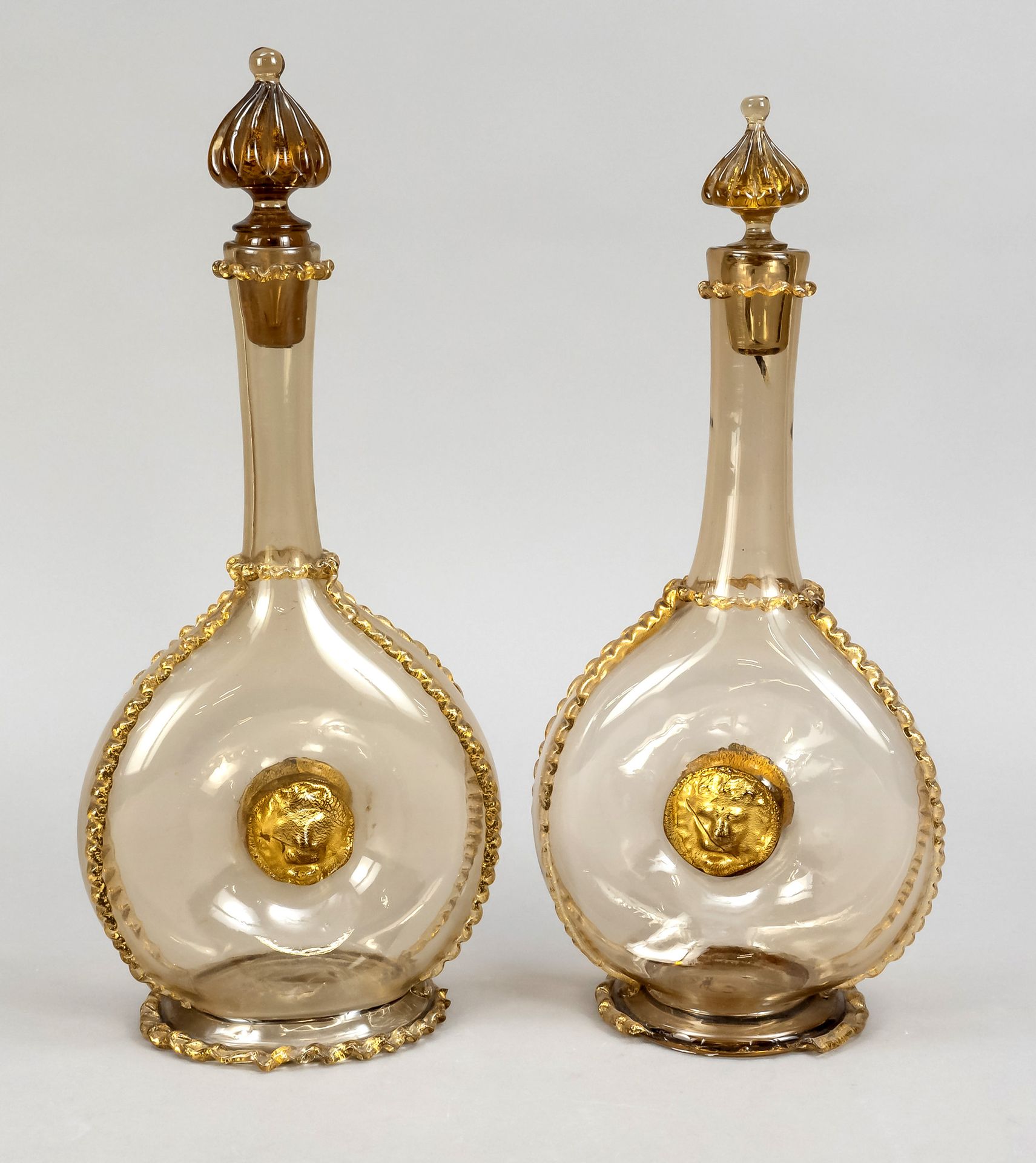 Null 一对水杯，可能是意大利，19世纪末，穆拉诺，朝圣者瓶子的形状，在椭圆形的支架上，圆盘形的身体，中央有凹槽，细长的脖子，瓶塞是一个旋钮的形状，棕色的玻璃&hellip;