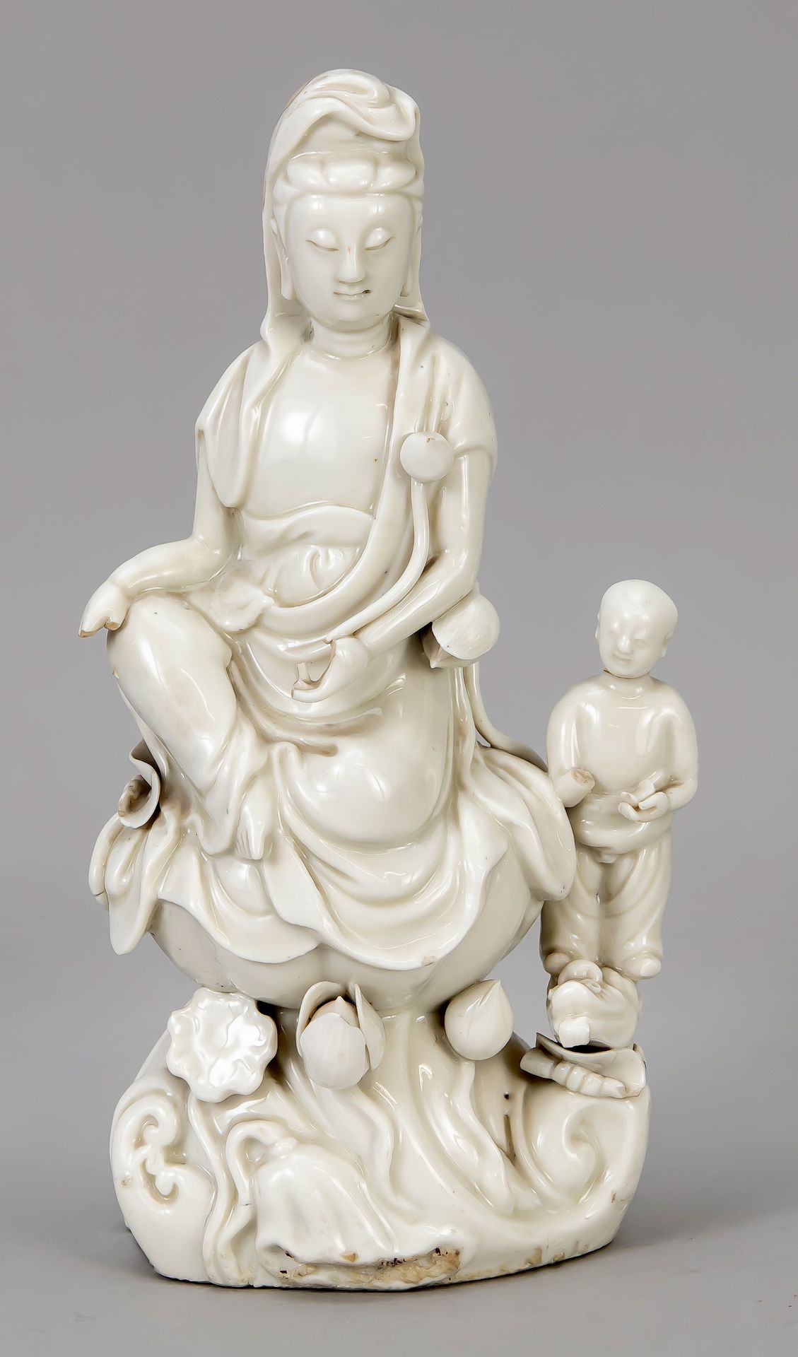 Null Blanc de Chine观音，中国，19世纪，坐在莲花宝座上，有小的支撑人物。多处磕碰，头部后部修复，高28厘米。