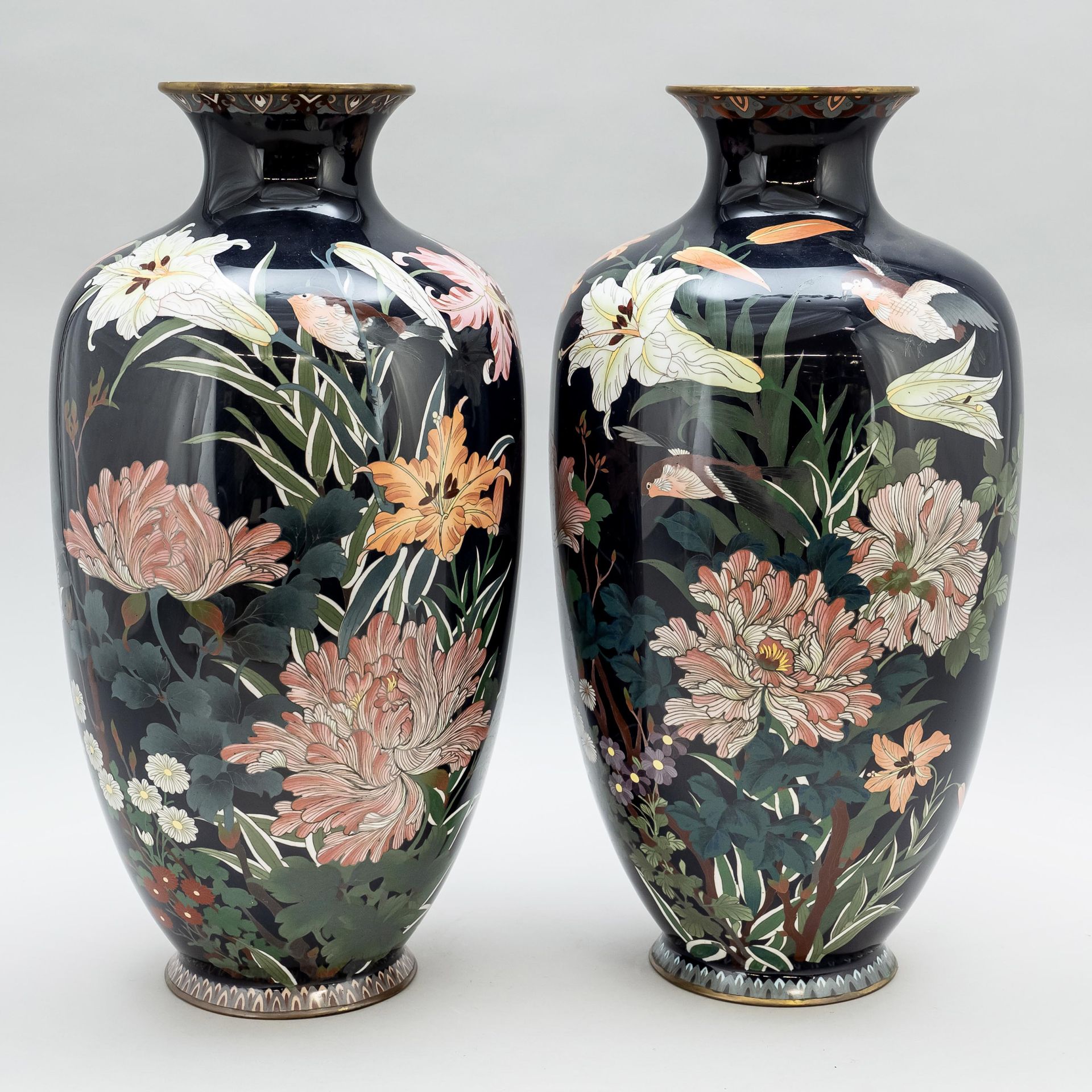 Null 一对景泰蓝花瓶，日本，约1900年。 装饰有飞鸟在开花的花朵和树枝之间，前面是深蓝色的地面。两只花瓶的肩部都有破损。其中一个花瓶里有一个小塑料袋，里面&hellip;