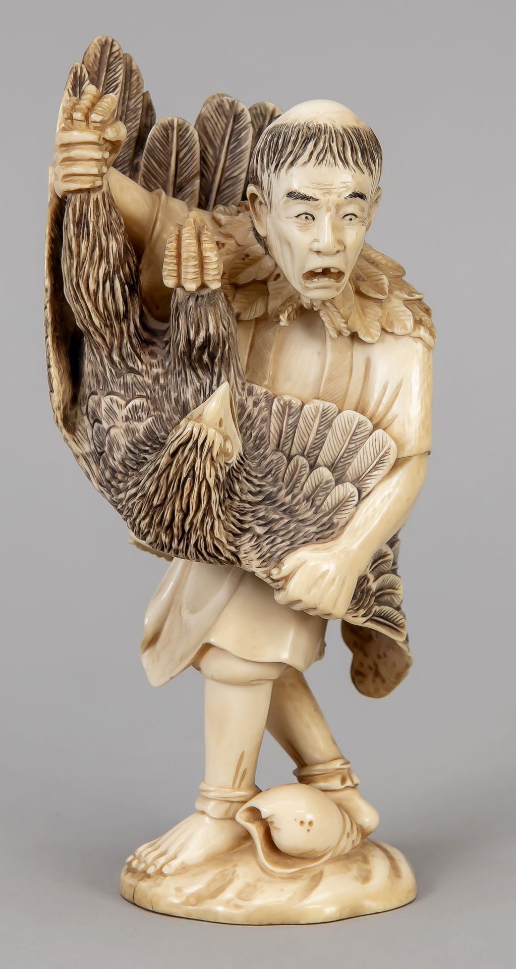 Null Okimono，日本，19世纪末（明治）。男子与海鹰搏斗，在一个带贝壳的地形基座上。发黑的切口装饰，底座下有切口签名，高16厘米。
