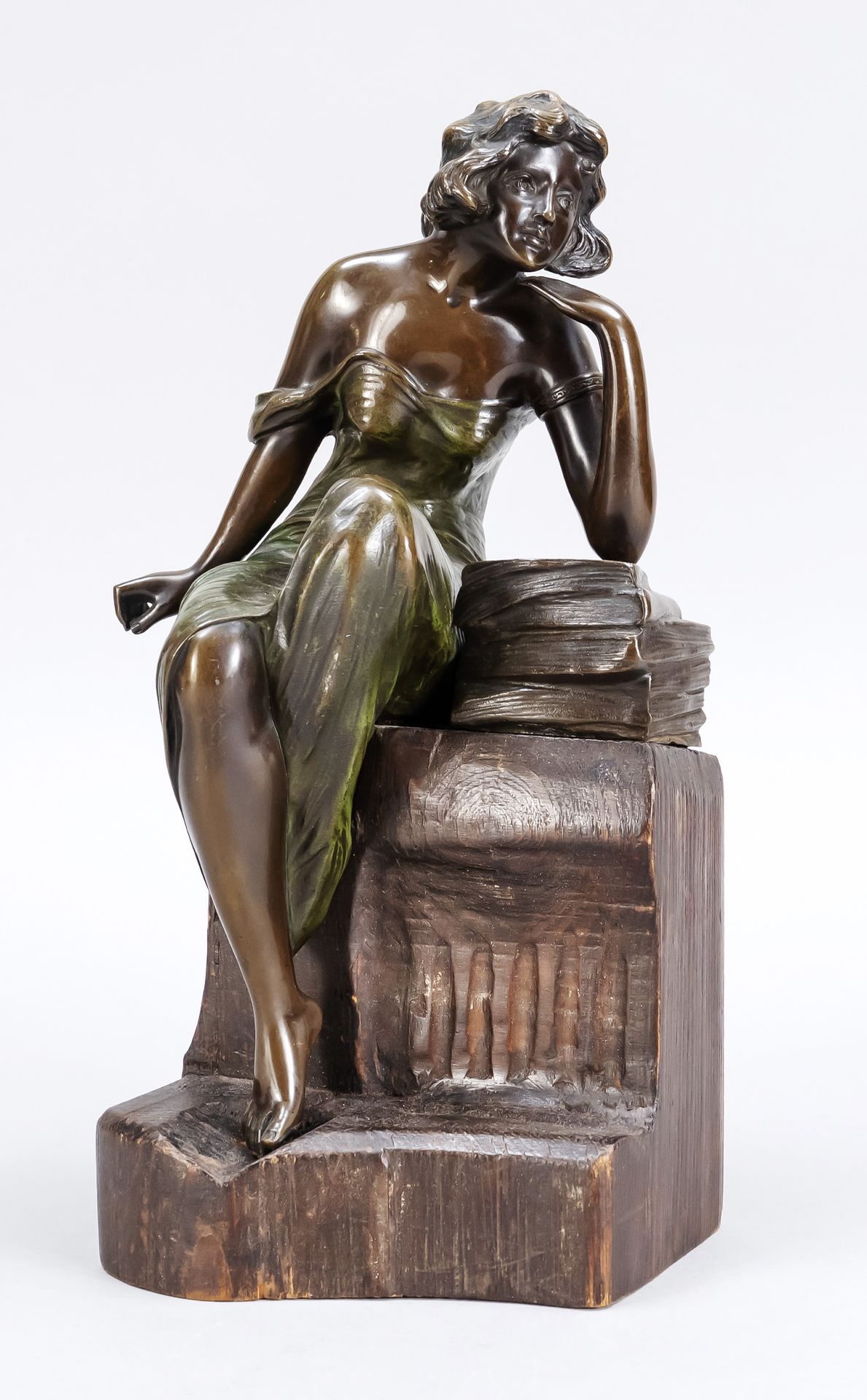 Null 匿名的新艺术派雕塑家，约1900年，一个年轻的女人坐在栏杆上，手里拿着一摞书，绿色和棕色的青铜，在橡木栏杆上，没有签名，高29厘米。