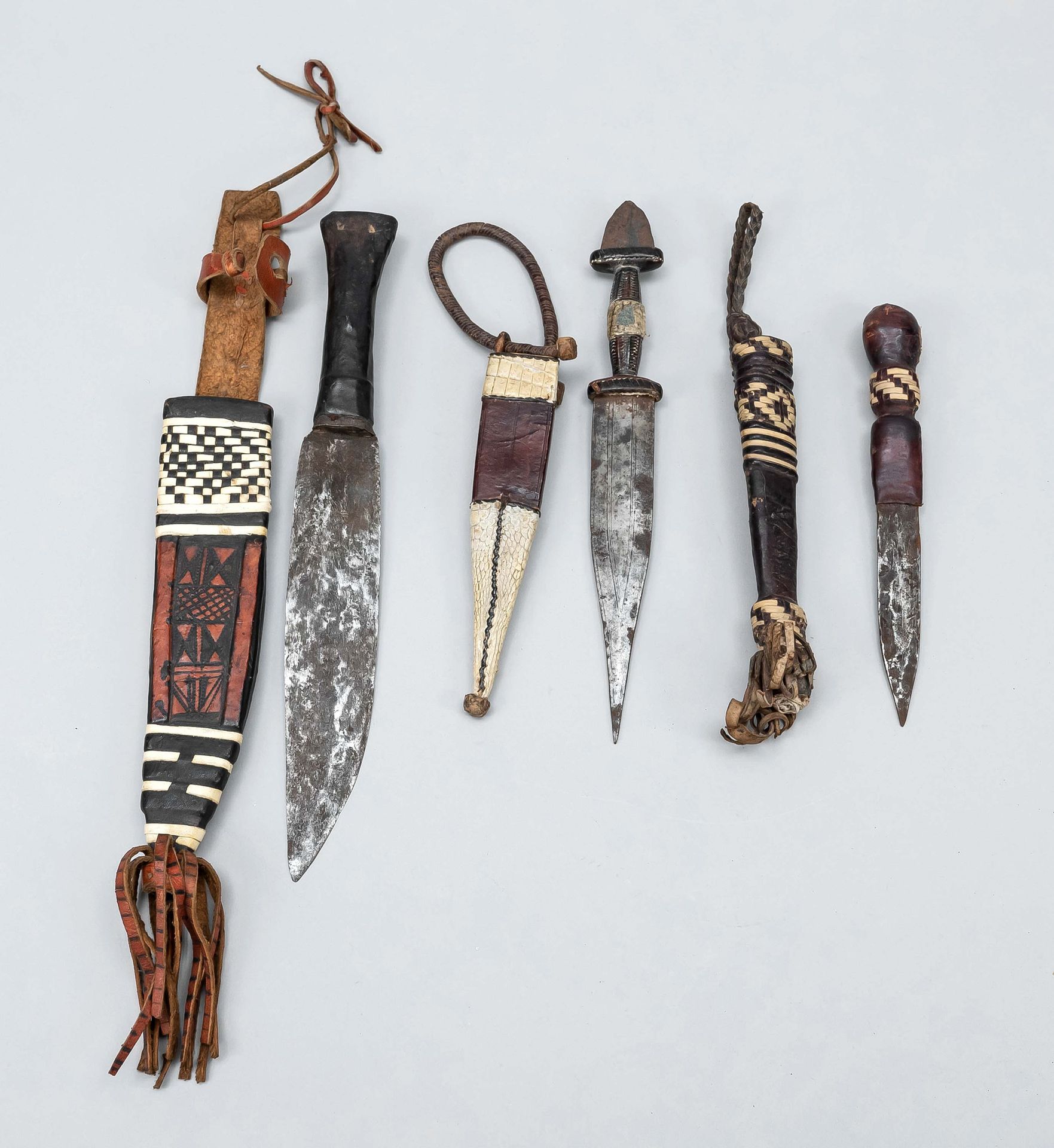 Null 三把仪式用匕首，可能是喀麦隆的，用皮革悬挂，部分因使用而磨损，刀刃部分有铜锈，长38厘米/长32厘米/长26厘米